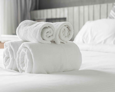 Elegance class white towels on bed with luxury duvet and hypoallergenic pillow
