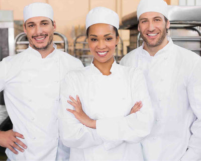Three Chefs wearing a white chef hat and white chef uniform