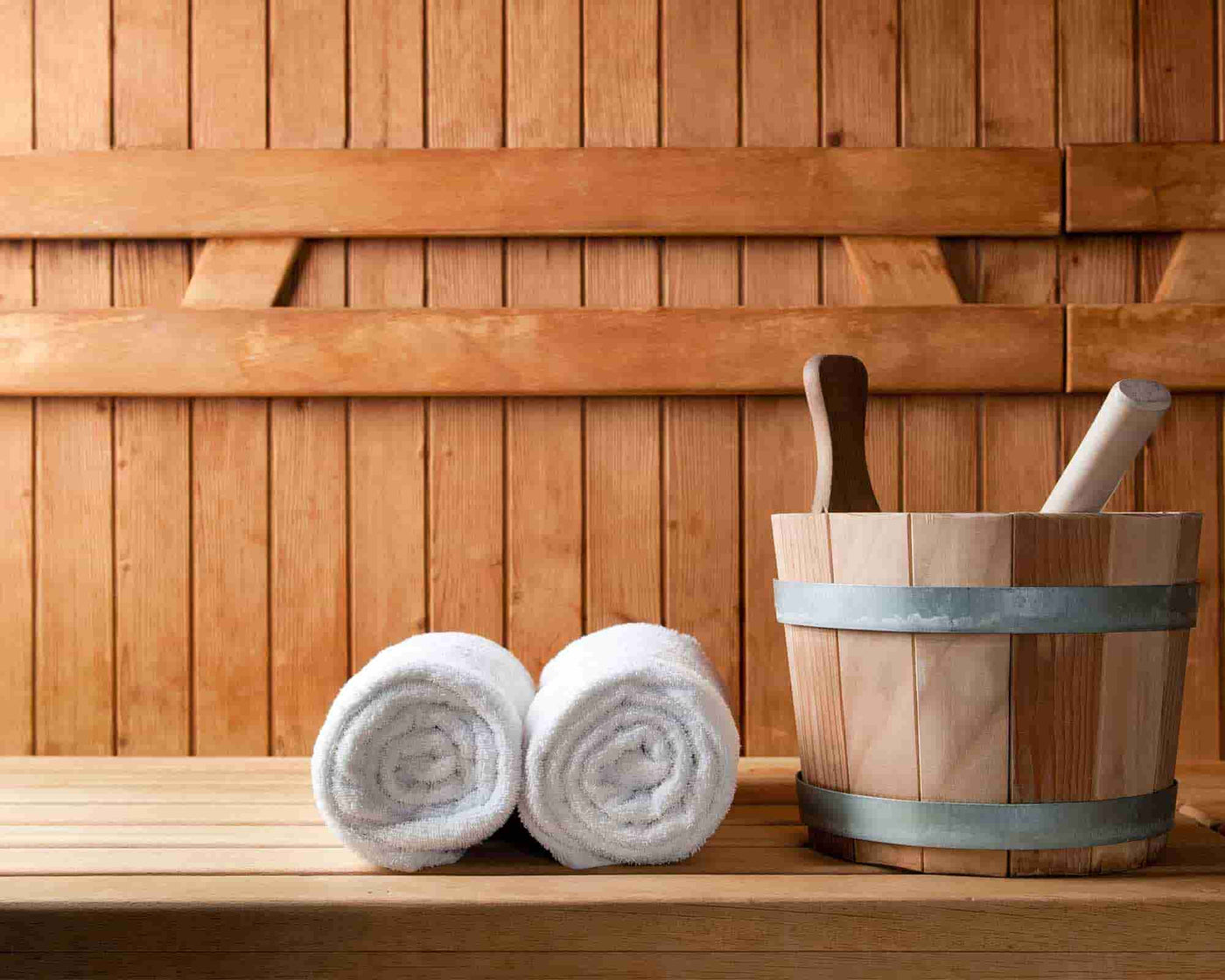 rolled white bath towels on wood table #colour_white