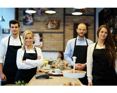 Four kitchen staff wearing black bib apron with no pocket