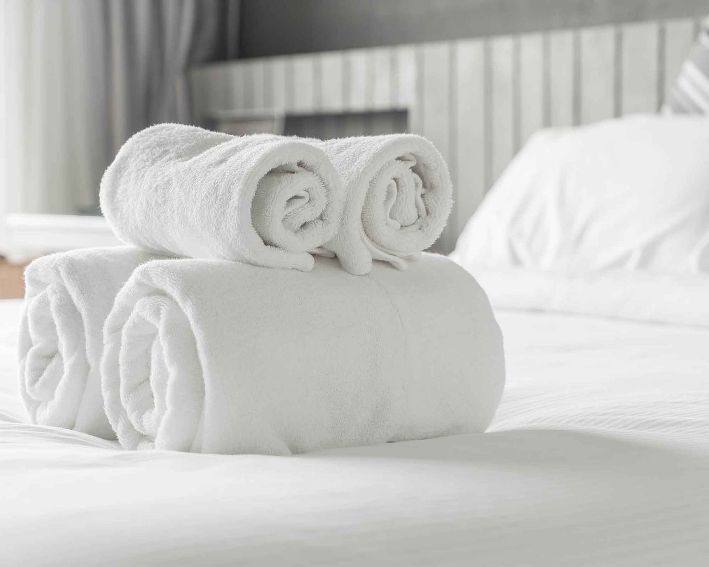 elegance rolled bath linen on the bed 