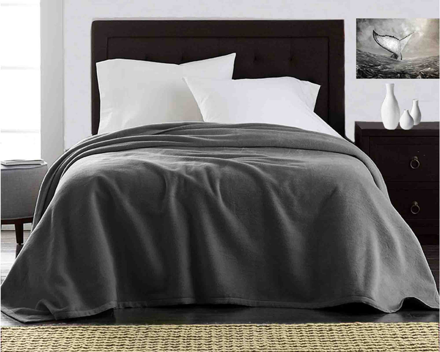 deep charcoal grey ultra plush fleece blanket on bed with white hypoallergenic pillows#colour_deep-charcoal-grey