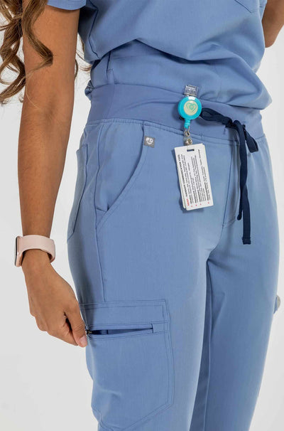 Vena ladies jogger style scrub pants showing side hip pocket with zipper#colour_ceil-blue