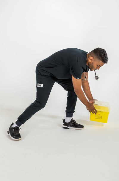 Vena mens jogger scrub pants man placing a yellow container onto the floor#colour_black