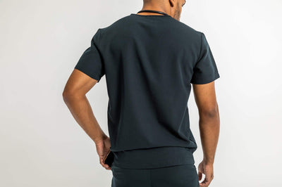 VENA mens jogger style scrub shirts, man featuring the back of the scrub#colour_black