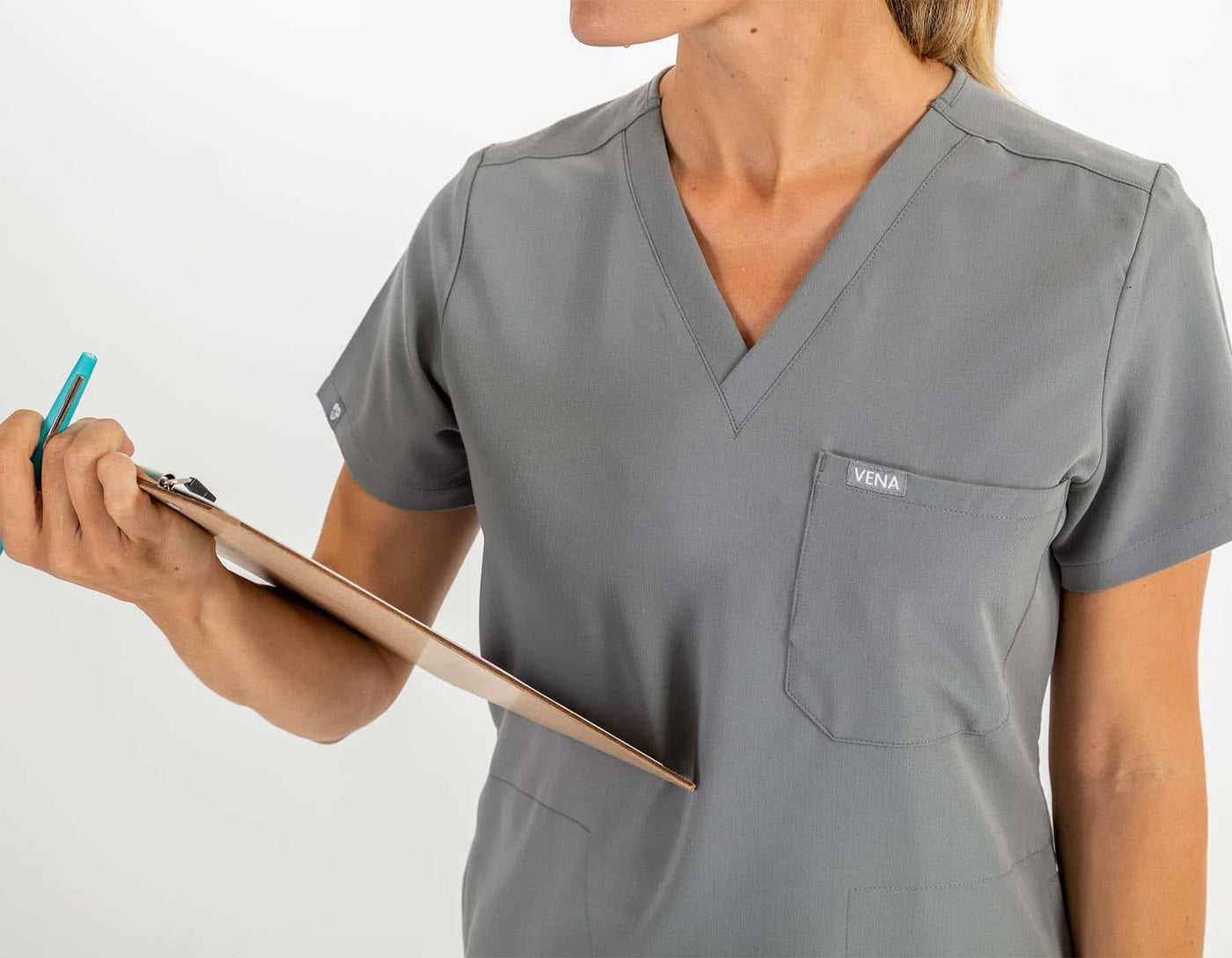 VENA ladies jogger style scrub shirt  zoom image of scrub shirt lady holding checklist in hand#colour_grey