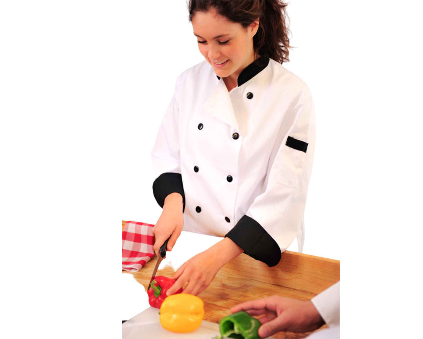 lady wearing white chef coat with black trim cutting vegetables#colour_white